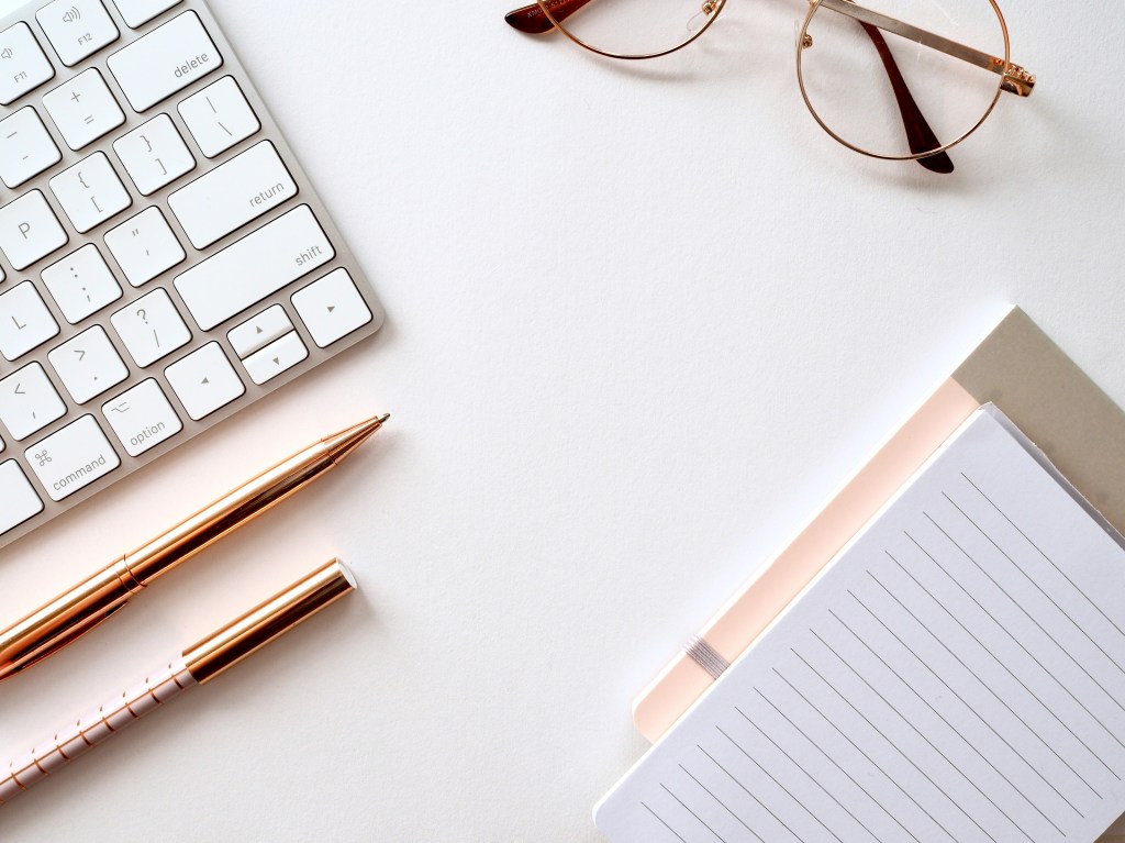 image of notepad, keyboard and pens Photo by Jess Bailey on Unsplash